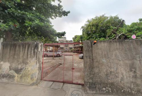 a gate with a red fence in front of a parking lot at Pousada Baobá e SPA in Olinda