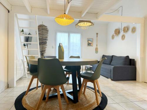 une salle à manger et un salon avec une table et des chaises dans l'établissement Chez Karine et Rodolphe La Cosy, piscines, plage, à Saint-Michel-Chef-Chef