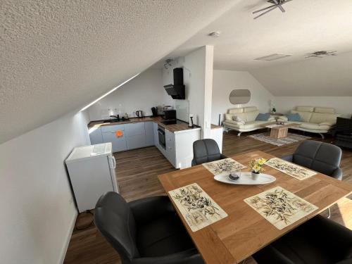 a living room with a dining table and a kitchen at Mevan Ferienwohnung in Gaienhofen