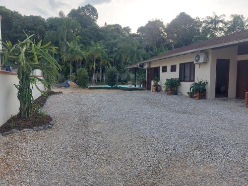 a gravel driveway next to a house and a building at Pitaya Haus Lofts in Brusque