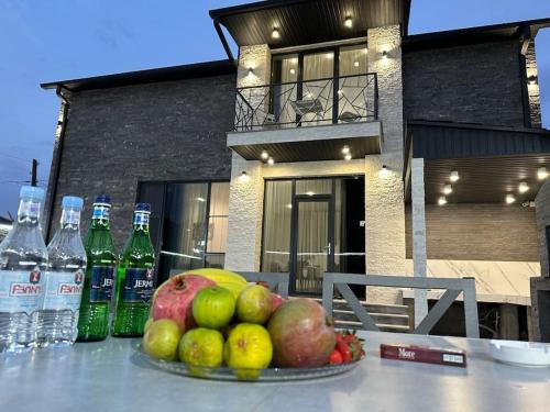 a bowl of fruit on a table with bottles of water at Batikyans' Villa Tsaghkadzor in Tsaghkadzor