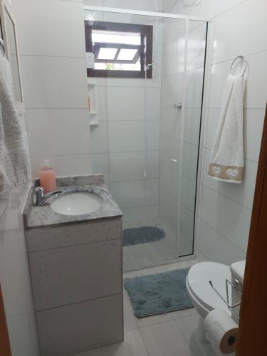 a bathroom with a shower and a sink and a toilet at Pitaya Haus Lofts in Brusque