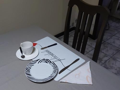 a table with a cup and a paper on it at Pitaya Haus Lofts in Brusque