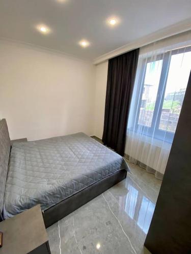 a bedroom with a bed and a large window at Batikyans' Villa Tsaghkadzor in Tsaghkadzor