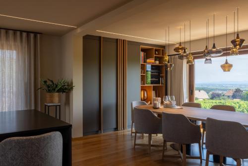 une salle à manger avec une table et des chaises et une fenêtre dans l'établissement La Villa du Morakopf - Colmar, à Niedermorschwihr