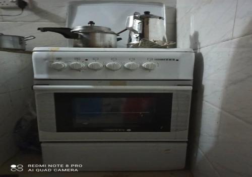 a white stove with a pot on top of it at Mlagala Room and Aparment Zanzibar 3 in Ngambo