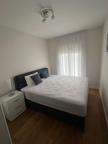 une chambre avec un grand lit et une fenêtre dans l'établissement Luxapartment Montenegro, à Podgorica