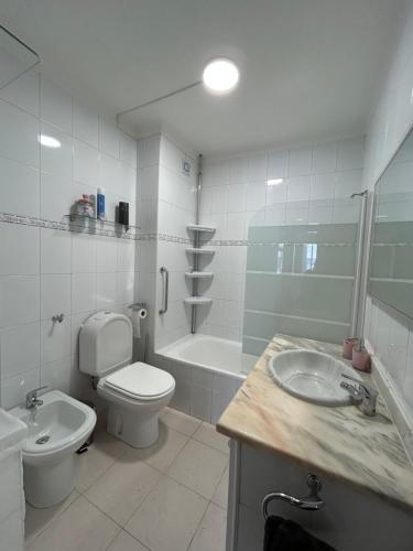 a white bathroom with a toilet and a sink at APARTAMENTO Casa Hortense in Olhão