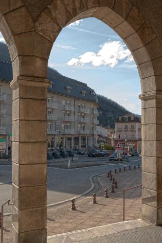 an arch in a building with a street and buildings at Résidence Le Grand Tétras- SPA THERMAL INCLUS in Ax-les-Thermes