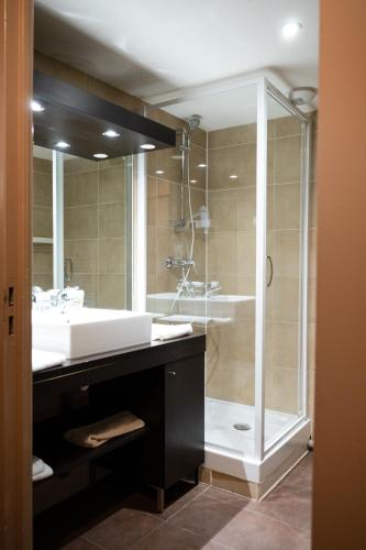 a bathroom with a shower and a white sink at Résidence Le Grand Tétras- SPA THERMAL INCLUS in Ax-les-Thermes