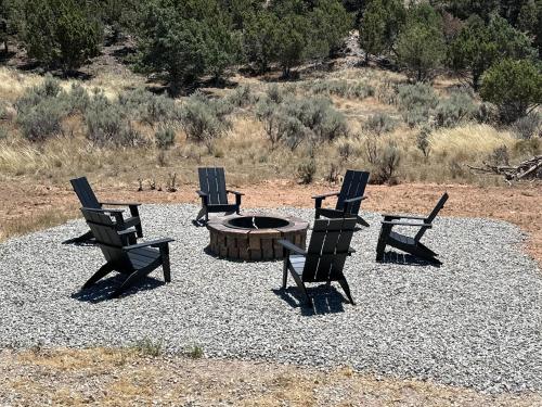 a group of chairs around a fire pit in a field at Beehive Basecamp Explore Ski Play and Make Memories in Parowan