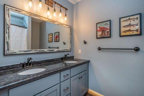 a bathroom with two sinks and a mirror at Parhelion Chalet in McHenry