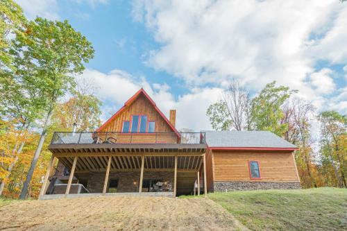 a barn house with a wrap around porch at Parhelion Chalet in McHenry