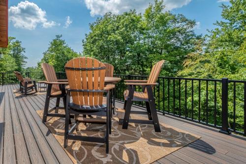 a patio with three chairs and a table on a deck at Parhelion Chalet in McHenry
