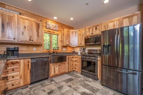 a kitchen with wooden cabinets and stainless steel appliances at Parhelion Chalet in McHenry