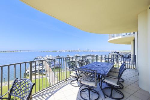 ein Balkon mit Tisch und Stühlen und das Wasser in der Unterkunft Phoenix on the Bay 1333 - Poseidon House condo in Orange Beach