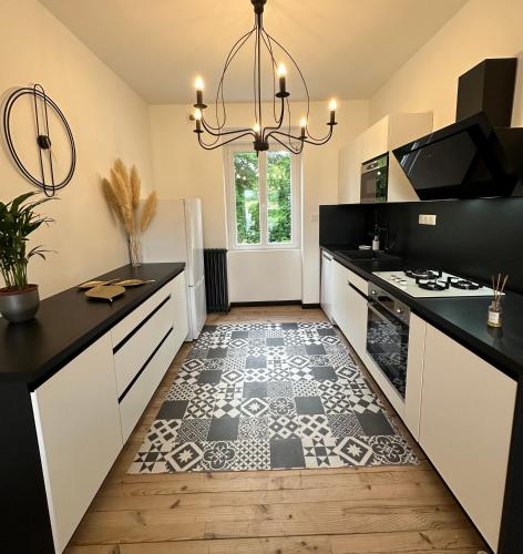 une cuisine avec un sol noir et blanc et un lustre dans l'établissement Maison vacance en Périgord, à Saint-Astier