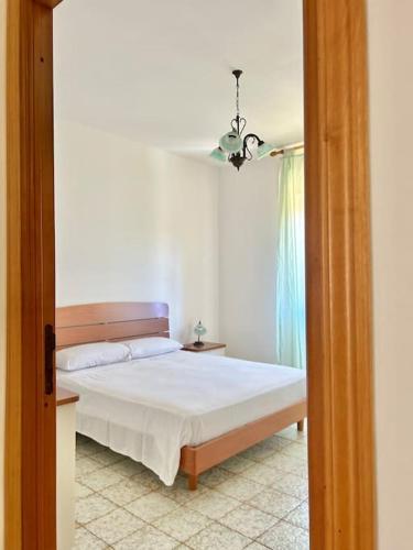 a bedroom with a white bed and a window at Nura's - Casa Girasole in Alghero