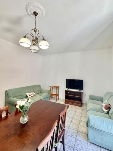 a living room with a table and two couches at Nura's - Casa Girasole in Alghero