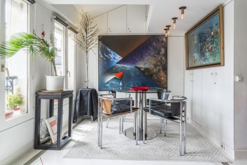 une salle à manger avec une table et des chaises devant un tableau dans l'établissement Loft central, à Paris
