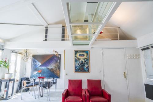 un salon avec des chaises rouges et une table dans l'établissement Loft central, à Paris