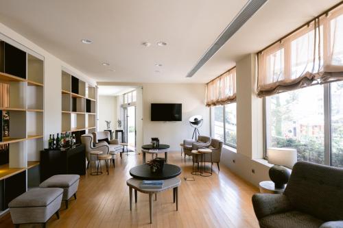 a living room with chairs and tables and a tv at Hotel Conde de Agueda in Águeda