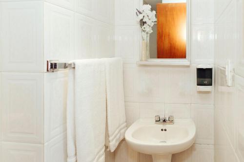 a white bathroom with a sink and a toilet at Hotel Don Simón in Toluca