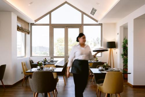 a man holding a tray in a restaurant at Hotel Conde de Agueda in Águeda