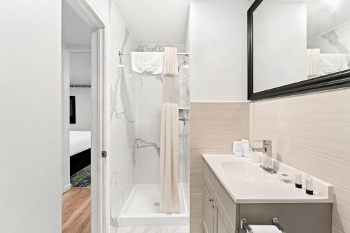 a white bathroom with a shower and a sink at Americas Best Value Inn Stonington Mystic in Stonington