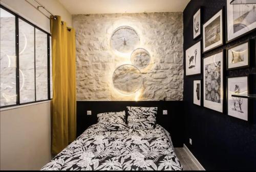 - une chambre avec un lit et un mur avec une horloge dans l'établissement 2 pièces centre-ville tout équipé, à Nîmes