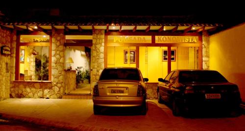 two cars parked in front of a shop at night at Pousada Konquista in Paraty