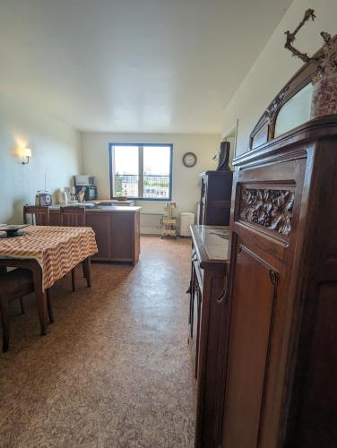 un salon avec une table et une cuisine dans l'établissement STUDIO 63M2 3EME ETAGE OU CHAMBRE DANS APPARTEMENT 2EME ETAGE pour SEJOURS A MOULINS, à Moulins
