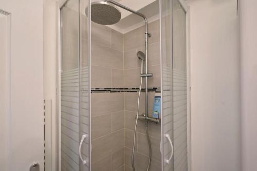 une douche avec une porte vitrée dans une salle de bain dans l'établissement La nouveauté Lilloise, à Lille
