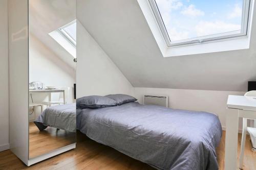 une chambre avec un lit et une lucarne dans l'établissement La nouveauté Lilloise, à Lille