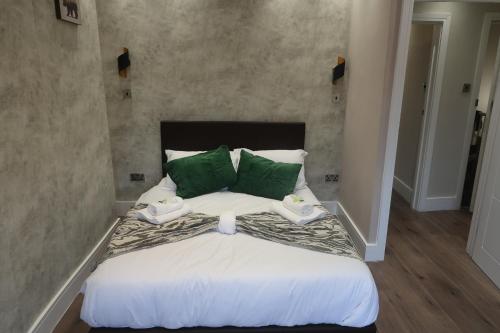 a bedroom with a large bed with green pillows at Casa Bella In Sherborne's Historic Quarterlocal in Sherborne