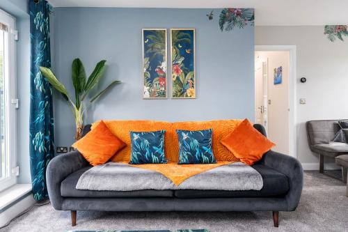 a living room with a couch with orange pillows at Doncaster Lakeside Paradise Place in Doncaster
