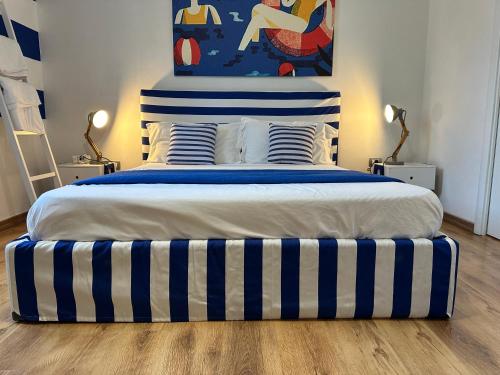 a bedroom with a large bed with blue and white stripes at Il Profumo del Mare GuestHouse in Cagliari