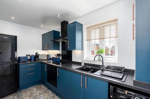 a kitchen with blue cabinets and a sink at Doncaster Lakeside Paradise Place in Doncaster