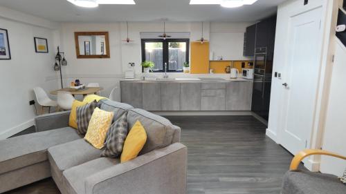 a living room with a couch and a kitchen at Guarlford Lodge in Malvern in Great Malvern