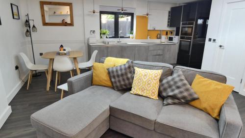 a living room with a couch and a kitchen at Guarlford Lodge in Malvern in Great Malvern
