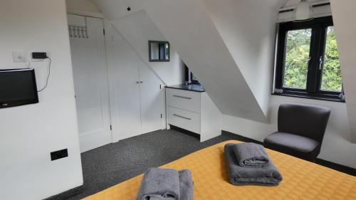 a room with a bed and a chair and stairs at Guarlford Lodge in Malvern in Great Malvern