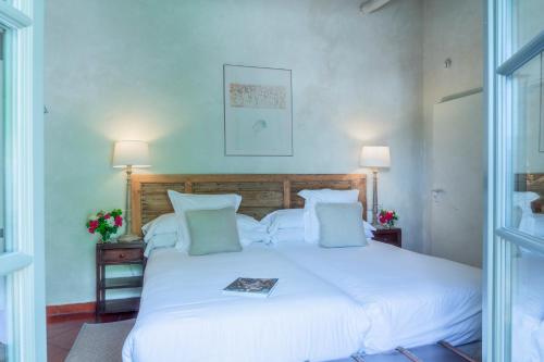a bedroom with a white bed with a book on it at Hotel Boutique Molino del Arco in Ronda