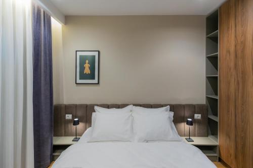 a bedroom with a large bed with white pillows at Prado Apartments in Pristina