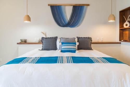 a bedroom with a large bed with blue pillows at Hotel Ysuri Bucerias in Bucerías