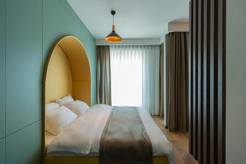 a bedroom with a bed and a large window at Prado Apartments in Pristina