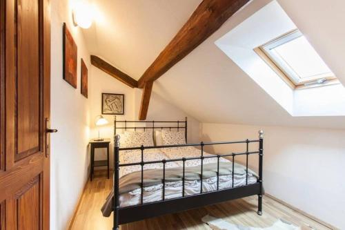 a bedroom with a black bunk bed and a skylight at House Maharac with 3 apartments till 15 persons in Kamno