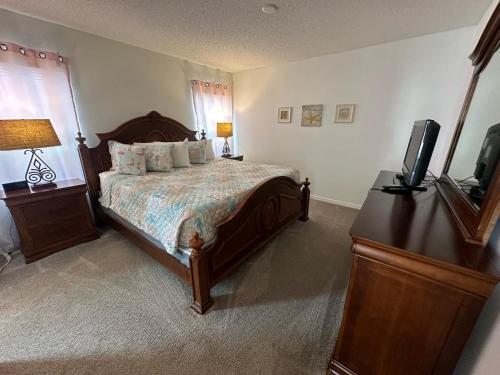 a bedroom with a bed and a flat screen tv at Beautiful 3-Bedroom Pool Villa in Southern Dunes in Haines City