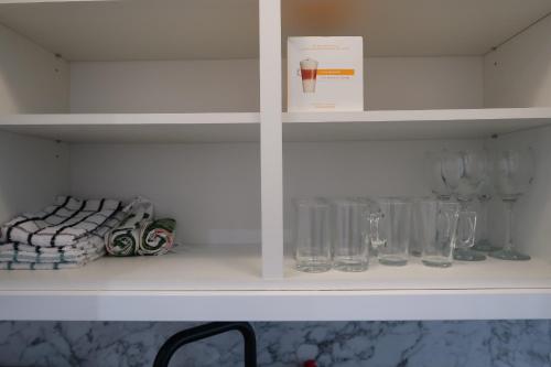 a white shelf with glasses and a box on it at Casa Bella In Sherborne's Historic Quarterlocal in Sherborne