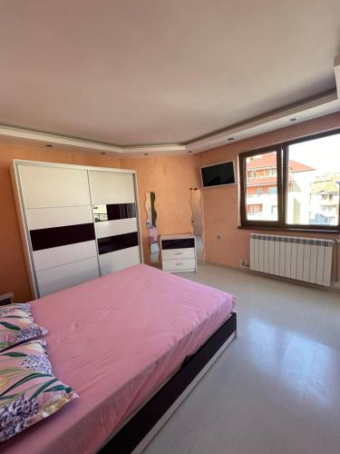 a bedroom with a bed and a large window at Луксозен апартамент in Vratsa