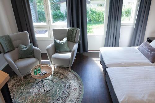a hotel room with two beds and a chair at Apartment Lumikontupa in Jyväskylä